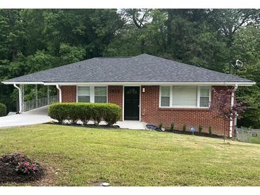 Charming brick home with a well-maintained lawn and covered parking at 2833 Oldknow Nw Dr, Atlanta, GA 30318