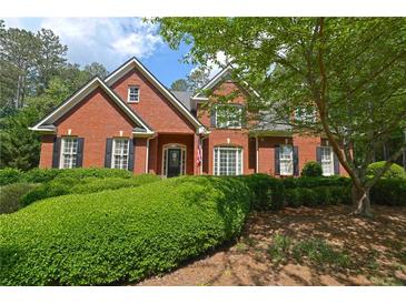 Charming two-story red brick home with mature landscaping, black shutters, and a welcoming entrance at 4810 Duncans Lake Dr, Buford, GA 30519