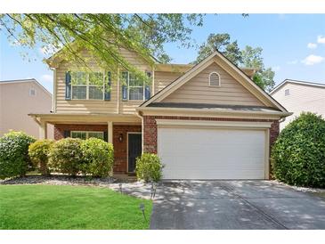 Charming two-story home featuring a brick facade and a two-car garage, surrounded by mature landscaping at 5244 Carrington Park Dr, Powder Springs, GA 30127