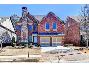Charming brick home featuring a stone chimney, two-car garage and professionally landscaped front yard at 4892 Kentwood Dr, Marietta, GA 30068