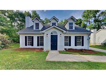 Charming home with a well-manicured lawn and a dark-blue front door, showcasing curb appeal at 5326 Nader Pl, Stone Mountain, GA 30088