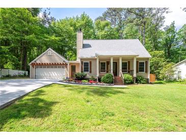 Charming home with a well-manicured lawn, a cozy front porch, and an attached garage at 3078 Alberta Dr, Marietta, GA 30062