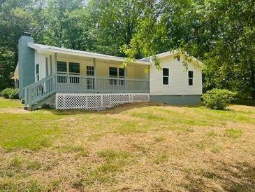 Ranch-style home with a covered front porch and mature trees at 97 East Rd, Covington, GA 30016
