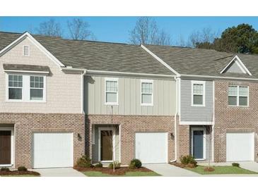 Charming townhome exterior with brick accents, single-car garages, and well-maintained landscaping at 400 Chaleur Way, Locust Grove, GA 30248