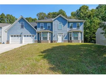 Charming two-story home featuring a two-car garage and beautiful blue siding at 6220 Polar Fox Ct, Riverdale, GA 30296