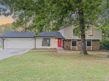 Charming two-story home with a well-maintained lawn, stone accents and bright red front door at 8007 Northcrest Dr, Jonesboro, GA 30238