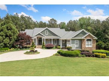 Stunning home with circular driveway, lush lawn, mature trees, and manicured landscaping at 1064 Highway 20 E, Mcdonough, GA 30252