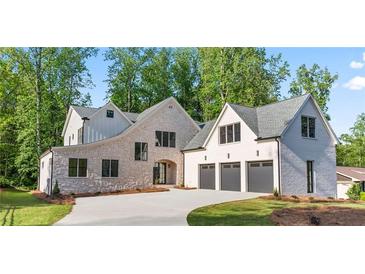 Stunning stone and brick home with a three-car garage and modern design elements at 3267 Sewell Mill Rd, Marietta, GA 30062