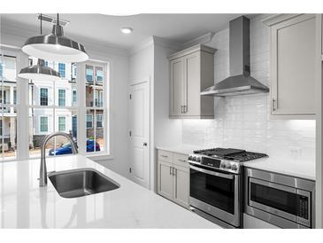 Bright kitchen featuring stainless steel appliances, a modern backsplash, and a large window at 3167 Moor View Rd # 35, Duluth, GA 30096