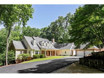 Stunning home showcasing stone and siding exterior, covered front porch, and lush landscaping at 5205 Riverview Nw Rd, Atlanta, GA 30327