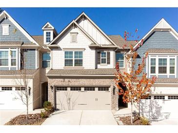 Charming two-story townhome with a brick facade and a two-car garage at 6348 Lanier Harbor Lndg, Buford, GA 30518