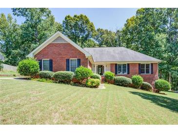 Beautiful brick home with a well-manicured lawn and lush landscaping, enhancing its curb appeal at 2903 Southpark Sw Ter, Conyers, GA 30094