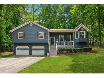 Charming two-story home features a covered porch, two-car garage, and lovely landscaped front yard at 76 Hollis Cir, Dallas, GA 30157