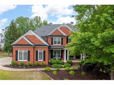Beautiful brick home featuring black shutters, columns, mature trees and manicured landscaping at 105 Thorncliff Way, Acworth, GA 30101