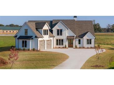 Stunning two-story farmhouse with a concrete driveway and well-manicured lawn at 170 Paislee Park (Lot #8 Paislee Park) Dr, Fayetteville, GA 30215