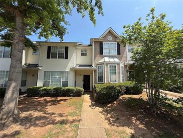 Two-story townhome with manicured front yard and walkway leading to the entrance at 229 Odyssey Turn, Conyers, GA 30012