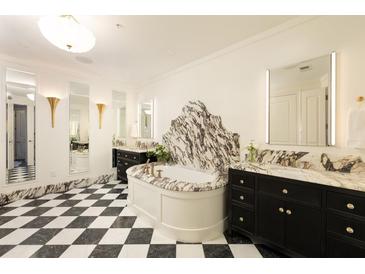 Elegant bathroom features a marble-clad tub, dual vanities, and striking black-and-white checkered flooring at 3344 Peachtree Ne Rd # 3005, Atlanta, GA 30326