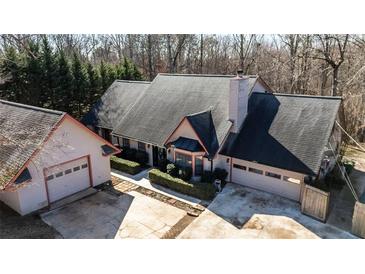 Aerial shot of house with well-maintained lawn, garage, and mature trees at 5479 Dorsett Shoals Rd, Douglasville, GA 30135