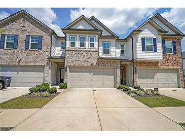 Charming townhome showcasing brick and siding facade with a private two-car garage and meticulously manicured front yard at 1312 Cooper Springs Rd, Grayson, GA 30017