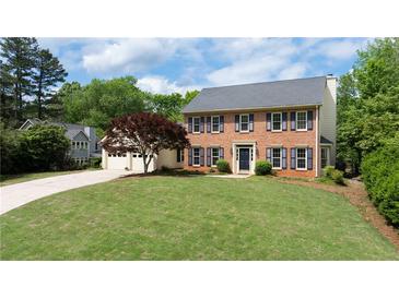 Charming two-story brick home featuring a well-manicured lawn and attached two car garage at 4085 Chadds Walk, Marietta, GA 30062