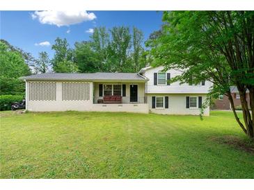 Charming home with a well-maintained lawn, a brick lattice accent, and a welcoming porch at 1448 Drayton Woods Dr, Tucker, GA 30084