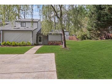 Charming townhome with a well-maintained lawn, mature trees, and inviting front entrance, showcasing curb appeal at 234 Pam Sw Ln, Marietta, GA 30064