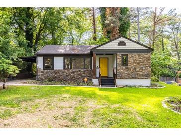 Charming bungalow-style home featuring stone accents, a bright yellow front door, and a well-maintained lawn at 1959 Oana Sw St, Atlanta, GA 30310