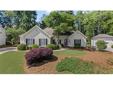 Charming single-story home featuring a well-manicured lawn, lush landscaping, and classic design at 11155 Highfield Chase Dr, Johns Creek, GA 30097