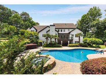 Backyard featuring a luxurious pool, stone spa, and lush landscaping, perfect for relaxation and outdoor enjoyment at 110 Hawks Bnd, Canton, GA 30115