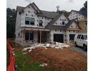 Unfinished two-story home featuring a multi-car garage and a classic roofline at 2467 Reed Se St, Smyrna, GA 30080