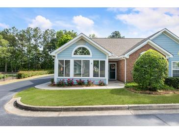 Charming home exterior with well-maintained landscaping, brick accents, and a cozy sunroom entrance at 15104 Harvest Ridge Ln, Alpharetta, GA 30022