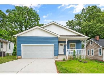 Charming blue home with a welcoming front porch and a two-car attached garage at 1924 Browns Mill Se Rd, Atlanta, GA 30315