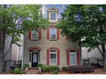 Charming two-story brick home featuring red shutters, manicured landscaping, and a welcoming front entrance at 319 Barbados Ln, Suwanee, GA 30024