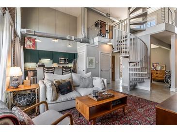 Stylish open-concept living room featuring a modern kitchen, cozy seating, and a striking spiral staircase at 791 Wylie Se St # 912, Atlanta, GA 30316
