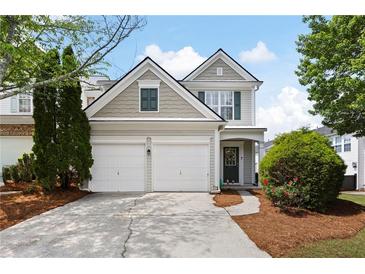 Charming two-story home with a two car garage and manicured landscaping and inviting curb appeal at 212 Regent Sq, Woodstock, GA 30188
