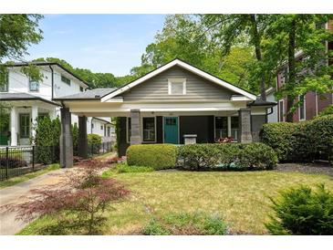 Charming bungalow with a welcoming front porch, lush landscaping, and a bright blue front door at 416 2Nd Ave, Decatur, GA 30030