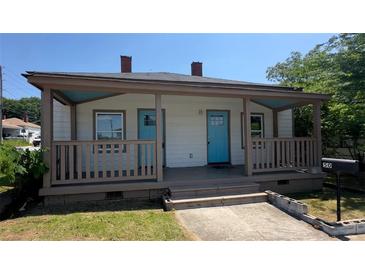 Charming one-story home with a welcoming front porch and light exterior and bright blue doors at 50 Ivy St, Porterdale, GA 30014