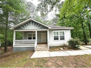 Charming single-story home with a welcoming front porch and beautifully landscaped yard at 2037 Lakewood Trl Se, Atlanta, GA 30315