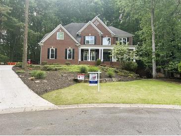 Charming two-story brick home with a manicured lawn and mature landscaping, creating an inviting curb appeal at 1045 River Pt, Suwanee, GA 30024