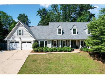 Charming traditional home featuring a two-car garage and inviting front porch with lovely landscaping at 4824 Dunwoody Station Dr, Atlanta, GA 30338