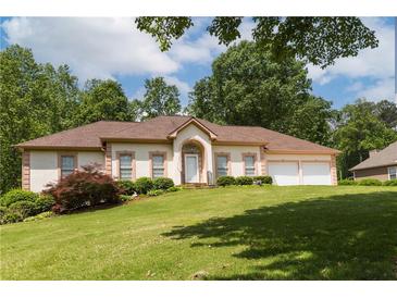 Charming one-story home with a well-manicured lawn and a two-car garage nestled among mature trees at 427 Picketts Lake Dr, Acworth, GA 30101