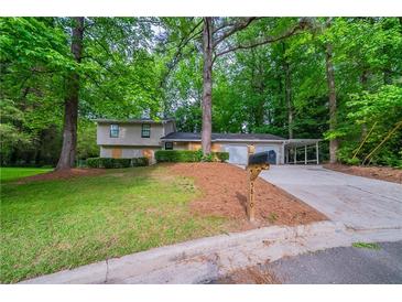 Charming home with a well-maintained front yard, covered parking, and mature trees at 5810 Tree Line Ter, Lithonia, GA 30058