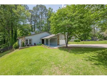 Charming single-story home featuring a well-manicured lawn and a cozy, covered entrance at 9985 Lake Forest Way, Roswell, GA 30076