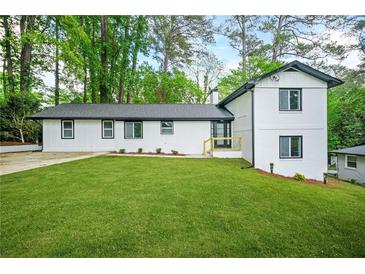 Newly renovated home with fresh white paint, contrasting black trim, and bright green lawn at 2813 Hillside Rd, Smyrna, GA 30080