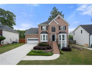 Charming two-story brick home with a well-manicured front lawn and attached two car garage at 1130 Lochshyre Way, Lawrenceville, GA 30043