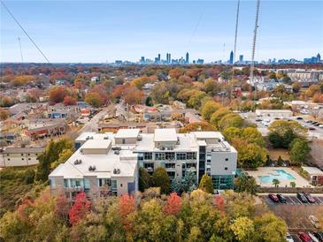 Stunning aerial view of modern apartments with a pool and city skyline in the background at 130 Arizona Ne Ave # 104, Atlanta, GA 30307