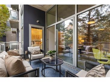 A cozy balcony with comfortable seating, a glass-topped table, and views of the surrounding greenery and bedroom inside at 130 Arizona Ne Ave # 104, Atlanta, GA 30307