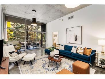 Modern living room with large windows, stylish furnishings, and concrete ceilings at 130 Arizona Ne Ave # 104, Atlanta, GA 30307