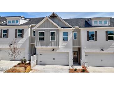 A modern townhome with a brick facade, a one car garage, and complimentary painted shutters at 1287 Fern Ridge Ct # 23, Norcross, GA 30093
