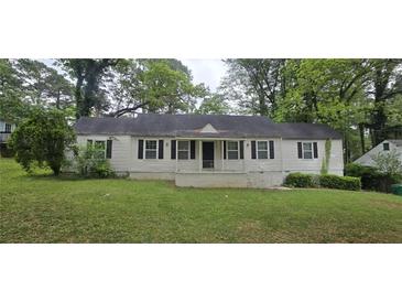 Traditional single-story home with a symmetrical facade, black shutters, and a well-maintained lawn at 1516 Carter Rd, Decatur, GA 30032
